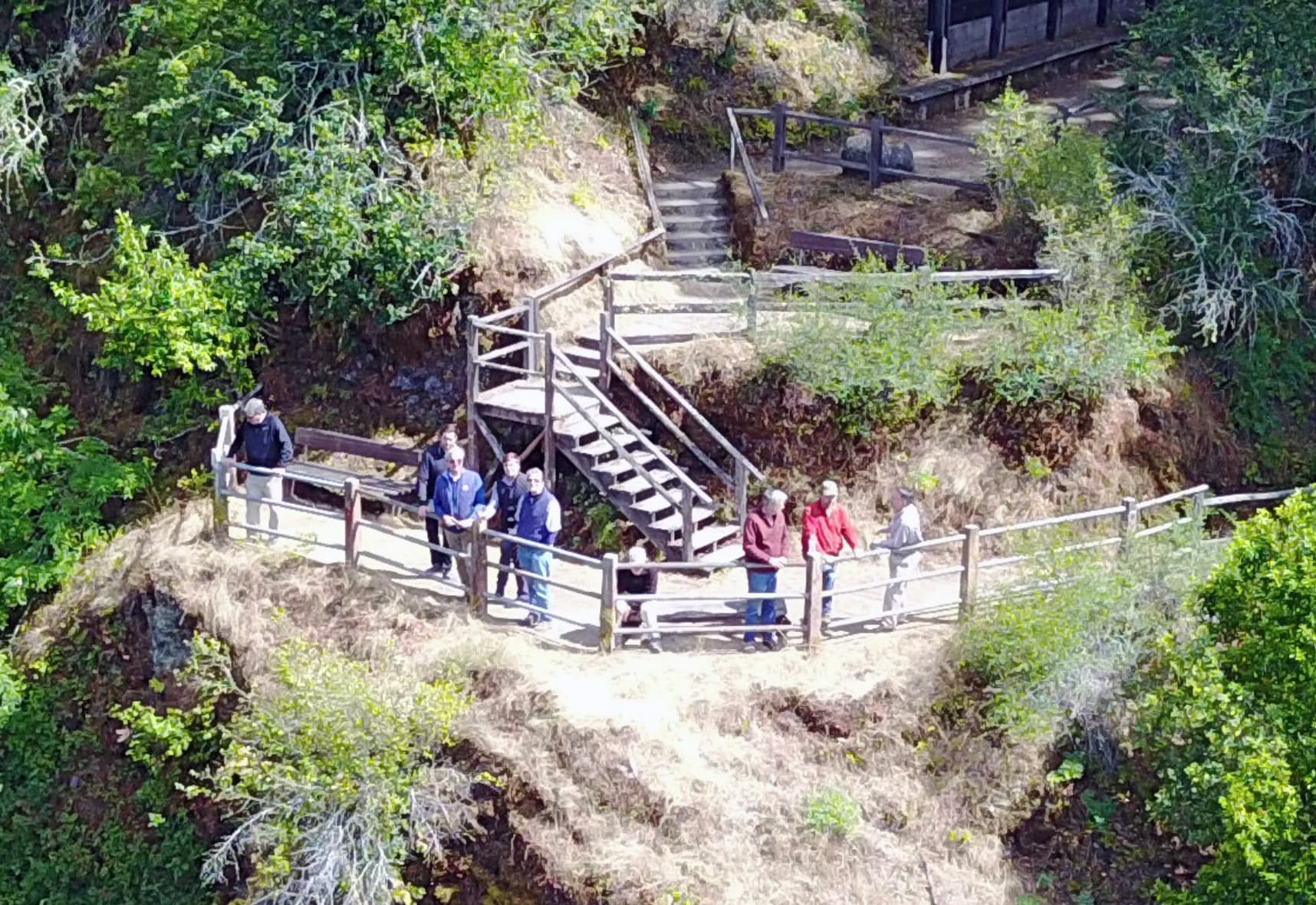 Bohemian Grove members lean against a fence during Spring Jinx encampment, date unknown.